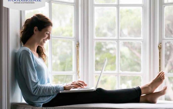 woman on laptop next to window
